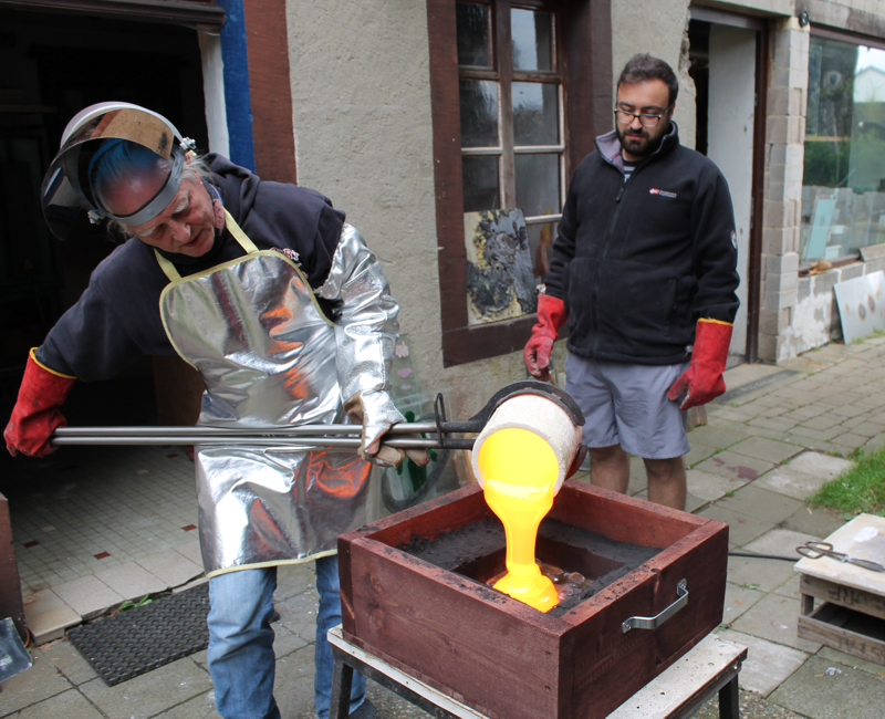  hot glass casting_pouring hot glass into a sand mold